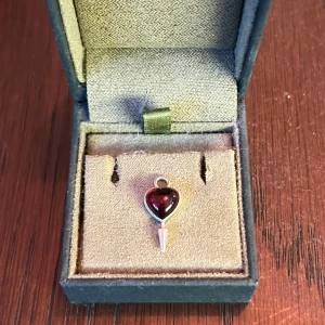 Maria Nilsdotter berlock i silver med röd sten - Säljer ett hjärtformat hänge i äkta silver (925) med en djupröd sten i mitten från Maria Nilsdotter. Hänget har en spetsig detalj nedtill och är perfekt som ett unikt smycke till halsband eller örhänge. Kommer i en fin ask. OBS endast berlock.❤️ möts upp i Stockholm!