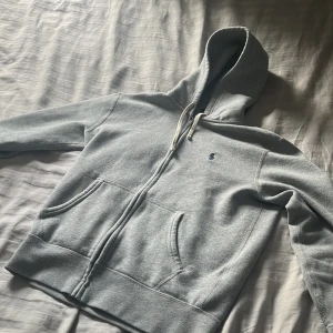 Grå hoodie från Polo Ralph Lauren - Säljer en klassisk grå hoodie från Polo Ralph Lauren med dragkedja och huva som är rätt svår att få tag på. Den är köpt på en butik som heter Pondus på smögen-bryggan och den kostade 1999kr. Bra skick och storlek S, hör av er vid fler frågor! 