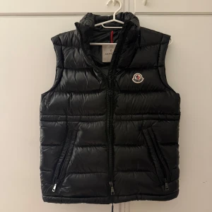 Moncler väst - Säljer min Moncler väst! Modellen heter "Ania Down Gilet" köpt fràn Moncler's hemsida för 2år sedan. Inga hal eller skador, sa inprincip nyskick! Är i barnstorlek i 12y/160 men är större i storlek, är 163 och använder annars S men denna passar mig perfekt