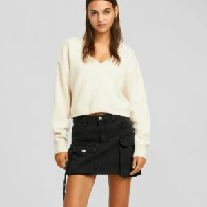 Beige v-ringad stickad tröja/kofta - Bershka - Superfin stickad tröja från Bershka i beige med v-ringning och långa ärmar. Tröjan har en loose passform och ribbade muddar vid hals, ärmslut och nederkant. Perfekt att styla med kjol eller jeans för en chill look. Materialet är mycket mjukt och tröjan är helt oanvänd! Skriv om ni har frågor samt innan ni köper! Nypris: 300kr (färgen på sista bilden är mörkare än vad tröjan är i verkligheten)