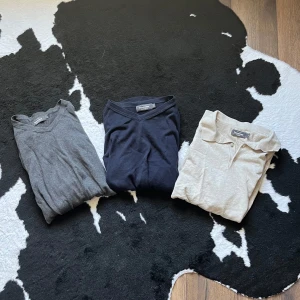 3-pack tröjor Dressmann, v-ringad & piké - Säljer tre stilrena tröjor från Dressmann i storlek S. En grå v-ringad tröja, en marinblå v-ringad tröja och en beige pikétröja med knappar. Alla är i mjuk bomull och passar perfekt till linnebyxor eller jeans nu på sommaren! | Skick 9/10 | Pris 300kr för allt! (Vill bli av med kläder från garderoben) | Skriv vid frågor eller funderingar! 