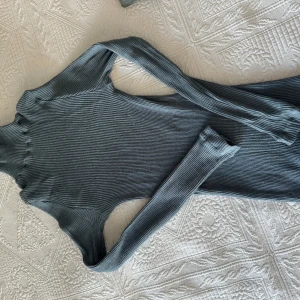 Ribbad grå polotröja från Intimissimi - Superskön ribbad polotröja i grått från Intimissimi. Tröjan har lång ärm, tight passform och hög krage som ger en clean och stilren look.