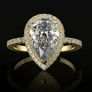 Droppformad ring med gnistrande stenar - Superfin ring med stor droppformad klar sten i mitten, omgiven av mindre gnistrande stenar. Finns både i guld- och silverfärgad variant. Perfekt statement piece för dig som vill sticka ut med extra bling. Gäller en i gyllene färg 