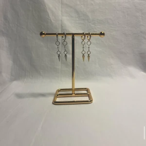 Hoops med kedjor och konhängen - Säljer två par hoops med kedjor och konformade hängen. Ena paret är i silverfärg och det andra i guldfärg. Snygg detalj med små ringar och minimalistisk design, perfekta för att ge din look edge.