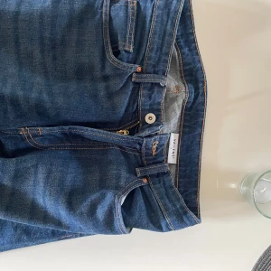 Blå jeans från Valient - Snygga blå jeans från Valient med klassisk femficksdesign och kontrastsömmar. Jeansen har raka ben och normal passform, tillverkade i slitstarkt denimtyg. Perfekta för en avslappnad och stilren look.