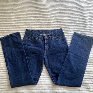 Blå jeans från Gul & Blå  - Klassiska blå jeans från Gul & Blå Blondie med raka ben och snygga kontrastsömmar. Jeansen är tillverkade i 100% bomull och har fem fickor samt läderpatch bak i midjan. Perfekta för dig som gillar en tidlös och clean look. Skriv gärna vid funderingar. 