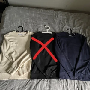 Sweatshirt tröjor i olika färger - Säljer tre stilrena crewneck tröjor i bomull – en beige, en svart och en mörkblå. Alla har rund hals, ribbade muddar och lång ärm. Perfekta för lager-på-lager och funkar året runt. Snygga att matcha och passar med allt. Storlek S sitter som S. Bra skick, få tecken på användning! Säljer för 99:- styck! (OBS den svarta är såld, de andra finns kvar!)