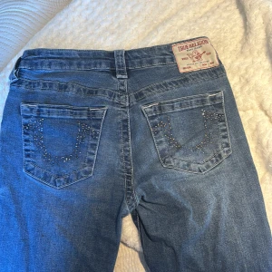 True Religion blå bootcut jeans - Snygga blå jeans från True Religion, bootcut med glitter på fickorna