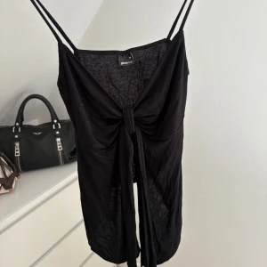 Topp med knytband - Svart linne med knytband från Gina Tricot i storlek M. Passar även L då materialet är väldigt stretchigt. Endast använd 2 gånger💓