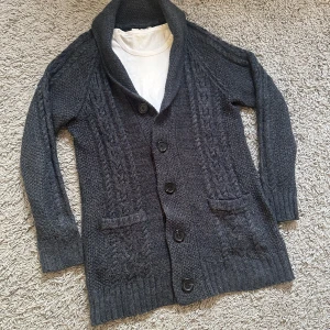 Stickad Cardigan - Säljer nu en riktigt snygg cardigan i marinblå och svart färg. 9/10 skick, inga defekter!! Pris kan diskuteras! Hör av dig vid intresse 😆