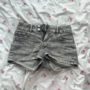 Grå jeansshorts från Lindex - Snygga grå jeansshorts från Lindex. Fina broderier på bak fickorna! Används runt 10 gånger.
