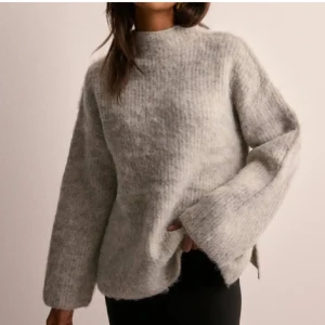 Grå stickad tröja från Pieces - Supermjuk och fluffig grå stickad tröja från Pieces med oversized passform och långa ärmar. Tröjan har en hög hals och är perfekt för kyliga dagar. Enkel att styla med både jeans och kjol för en chill look. Nypris 600kr, använd en gång