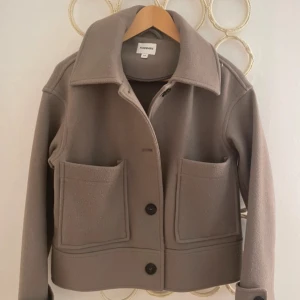 Beige kappa från Kappahl -  beige kappa från Kappahl i storlek XS. Jackan har stora fickor framtill, perfekt för höst och vintern, aldrig använt 