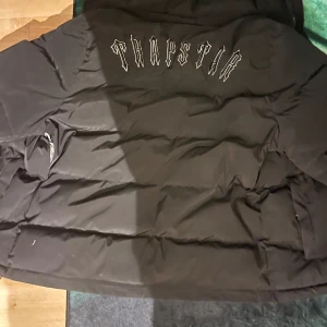 Trapstar jacka - De är en trapstar jacka med broderad text på ryggen. De är ett litet hål bak på ryggen men inget man märker av, går även att sy ihop hur enkelt som helst. Ingen luva fås med då den är borta. Prins kan diskuteras