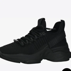 Svarta sneakers från Steve Madden - Snygga helsvarta sneakers från Steve Madden med chunky sula och stickad ovandel. Skorna har snörning med svarta och vita detaljer samt logga på sidan och plösen. Perfekta för dig som gillar sportig och modern stil. Använd ett par gånger bara.