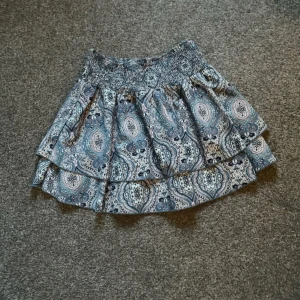 Blå mönstrad volangkjol - Volangkjolen är i bra skick, använd ett få antal gånger. ❤️