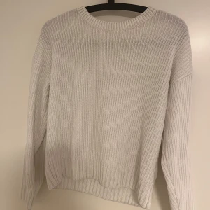 Vit ribbstickad tröja med rund hals från new yorker - En stilren vit ribbstickad tröja med rund halsringning och långa ärmar. Tröjan har en relaxed passform och är perfekt för lager-på-lager. Mjuk och skön känsla, passar till jeans eller kjol för en clean look. Lappen är borttagen då den syntes igenom tröjan, storlek XS