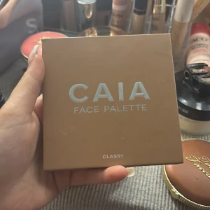 CAIA Face Palette Classy - Säljer en CAIA Face Palette i färgen Classy med fyra olika puder: bronzer, rouge, highlighter och contour. Paletten har en spegel och kommer i en snygg beige/brun förpackning. Perfekt för att skapa en fräsch och glowig look.