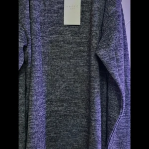 Gråmelerad stickad tröja Kaffe Curve - Mysig gråmelerad stickad tröja från Kaffe Curve. Tröjan har lång ärm och en klassisk rund halsringning. Perfekt för lager-på-lager och chill dagar. Enkel och stilren design som funkar till allt.