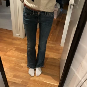 Blå bootcut jeans Nine in the Morning - Snygga blå jeans från Nine in the Morning med bootcut passform och råa, fransiga benslut. Klassisk femficksmodell med låg midja.