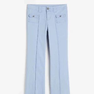 Ljusblåa lågmidjade bootcut jeans - Ljusblåa lågmidjade bootcut jeans med design som är slutsålda och super populära, passar mig som har på mig storlek XS