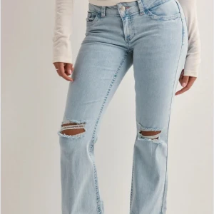Lågmidjade bootcut jeans med hål - Lågmidjade jeans från Nelly med hål,  i storlek 34. Nypris 699 använda ett få tal gånger bra skick  
