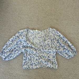 Blommig blus med puffärm från H&M - Supersöt blus från H&M med blått blommönster. Den är nästan aödrig använd 