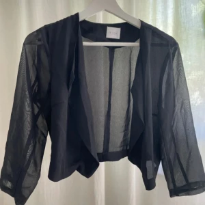 Svart transparent overshirt från Vila - Snygg svart transparent overshirt/blus/kofta/kavaj får vila med öppen front. Perfekt att slänga över en topp, T-shirt eller ett linne. 