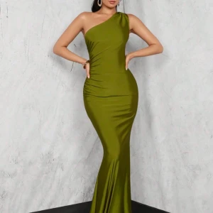 Olivgrön långklänning oneshoulder - Supersnygg olivgrön långklänning med figurnära passform och oneshoulder-design. Klänningen har en elegant, slät yta och markerar midjan på ett stilrent sätt. Perfekt för dig som vill sticka ut med en modern och trendig look.