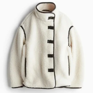 Vit teddyjacka med svarta detaljer - Supermysig vit teddyjacka med svarta kanter och knäppning framtill. Jackan har hög krage, oversized passform och långa ärmar. Jättefin men kommer tyvärr inte till användning då jag har så många jackor. Helt slutsåld på H&M 🥰❤️ (bild 3 är lånad från annan annons)