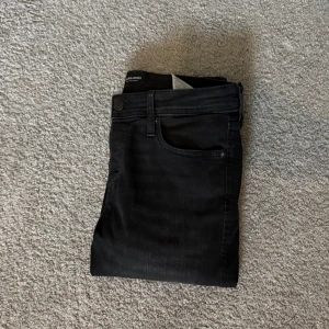 Svarta jeans från Jack & Jones - Säljer ett par svarta slim Glenn jeans från Jack n Jones! Väldigt bra skick( använda fåtal gånger)! Storleken: 31:32!! Pris 300! Hör av dig vid frågor och funderingar!