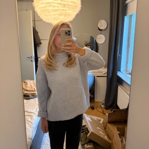 Ljusblå stickad tröja med loose fit - Mysig ljusblå stickad tröja med rund hals och långa ärmar. Tröjan har en loose passform och ribbade muddar vid ärmslut och nederkant. Perfekt för dig som gillar en chill och avslappnad stil. Passar till svarta jeans eller leggings.