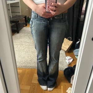Blå bootcut jeans från Reactive - Säljer ett par blå bootcut jeans från Reactive med snygg slitning och dubbla knappar i midjan. Tyvärr för små för mig, strl W27 L32