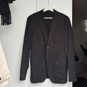 Svart kavaj från Oscar Jacobson - Riktigt snygg svart kavaj från Oscar Jacobson med klassisk smal design, kond 9/10.                                       Nypris:4499kr men säljer nu för 1000kr och kan diskutera pris. Hör gärna av dig för fler bilder eller om du har någon fråga 🙌🏽