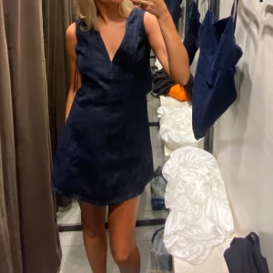 Denimklänning från Zara - Supersnygg denimklänning från Zara med v-ringning och öppen rygg. Använd en gång bara så helt i nyskick! Så så så snygg men använder den inte då jag har en typ likadan…