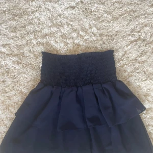 Mörkblå volangkjol med smock - Supersöt mörkblå kjol med bred smock i midjan och dubbla volanger💙