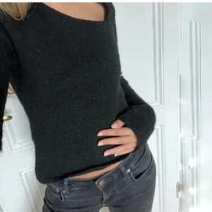 Svart stickad tröja med asymmetrisk ringning - Snygg svart stickad tröja med lång ärm och unik asymmetrisk halsringning💕💕.