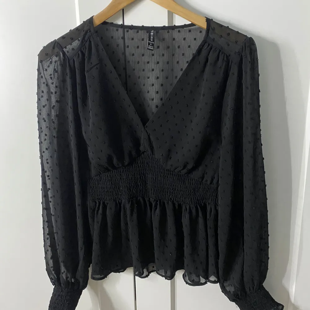 Detta är en jättefin nästan oanvänd svart blus. Den har långa armar och är stretchig vid midjan och handlederna. Passar perfekt för en fin middag eller fest!. Puserot.