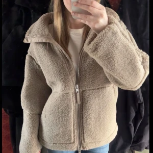 Teddyjacka från H&M - Mysig beige teddyjacka från H&M med dragkedja framtill. Köpte här på plick för 600 men säljer då de va lite skador på höger ficka. Det är inte hål, skulle säga att fleecen har försvunnit lite (bild 3 och 4). Det märks egentligen inte så mycket om man ruffsar till det som jag har gjort på bild 4, men skulle kunna diskutera priset. 💞