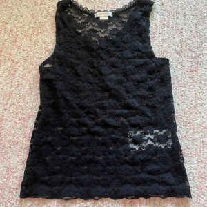 Svart spetslinne från Gina Tricot - Säljer ett snyggt svart spetslinne från Gina Tricot. Linnet är ärmlöst och har ett vackert spetsmönster som ger en elegant touch. Perfekt för att lägga till lite stil i din garderob. 🖤