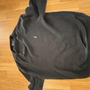 Svart  tröja från Polo Ralph Lauren - Säljer en stilren svart tröja från Polo Ralph Lauren med det klassiska broderade logotypen på bröstet. Tröjan har långa ärmar och en rund halsringning. Perfekt för en avslappnad och snygg look. helt äkta 