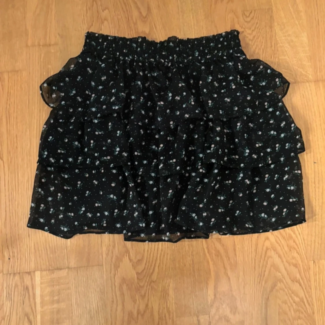 Svart blommig kjol med volanger