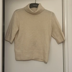 Beige polotröja från H&M - Säljer en stilren beige polotröja från H&M. Tröjan har trekvartsärmar och en klassisk polokrage, perfekt för kyligare dagar. Materialet är mjukt och bekvämt, vilket gör den till ett mångsidigt plagg i garderoben.