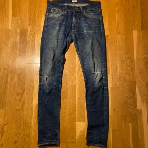 Edwin jeans - Snygga blå Edwin jeans med en slim tapered passform och låg gren. De har en klassisk femficksdesign och slitna detaljer vid knäna för en trendig look. Perfekta för en avslappnad stil. Ifall mer frågor skriv gärna!