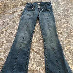 Blå bootcut jeans från Nelly - säljer supersnygga blåa lågmidjade bootcut jeans från Nelly med dubbla knappar. säljer pga att dem inte kommer till användning, endast använda 3-4 ggr. köpte nya för 699kr, pris är diskuterbart. skriv gärna vid frågor🩷