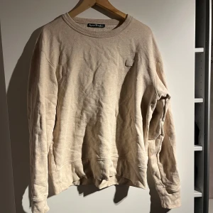 Beige tröja från Acne Studios - Säljer en stilren beige tröja från Acne Studios. Tröjan har en rund halsringning och långa ärmar. Perfekt för en avslappnad look.