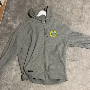 hoodie Hammarby - Säljer en grå hoodie från Craft med dragkedja och ett tryck av Hammarby. Perfekt för kyliga dagar med sin bekväma passform och praktiska fickor. Hör av dig vid intresse!