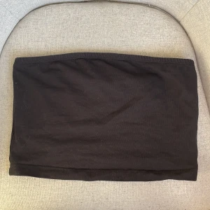 Svart tubtopp från Even&Odd - Säljer en stilren svart tubtopp från Even&Odd. Perfekt för att matcha med olika outfits. Enkel och bekväm design. Passar både xs/s. Skriv för fler bilder.