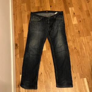 Mörkblå jeans från Lee - Säljer ett par mörkblå jeans från Lee med klassisk femficksdesign och dragkedja. Jeansen har en slim, straight passform och är tillverkade i denim. Perfekta för en avslappnad stil.
