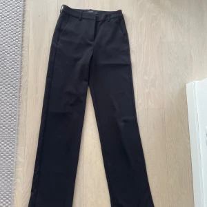 Svarta kostymbyxor - Säljer dessa svarta kostymbyxor från Vero Moda! Byxorna har tecken på användning, därav det billiga priset.
